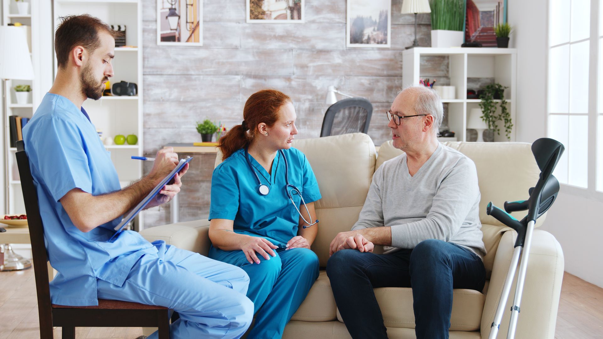 Healthcare professionals providing care and consultation to senior man at home, illustrating aged care jobs Melbourne no experience and supportive entry level roles
