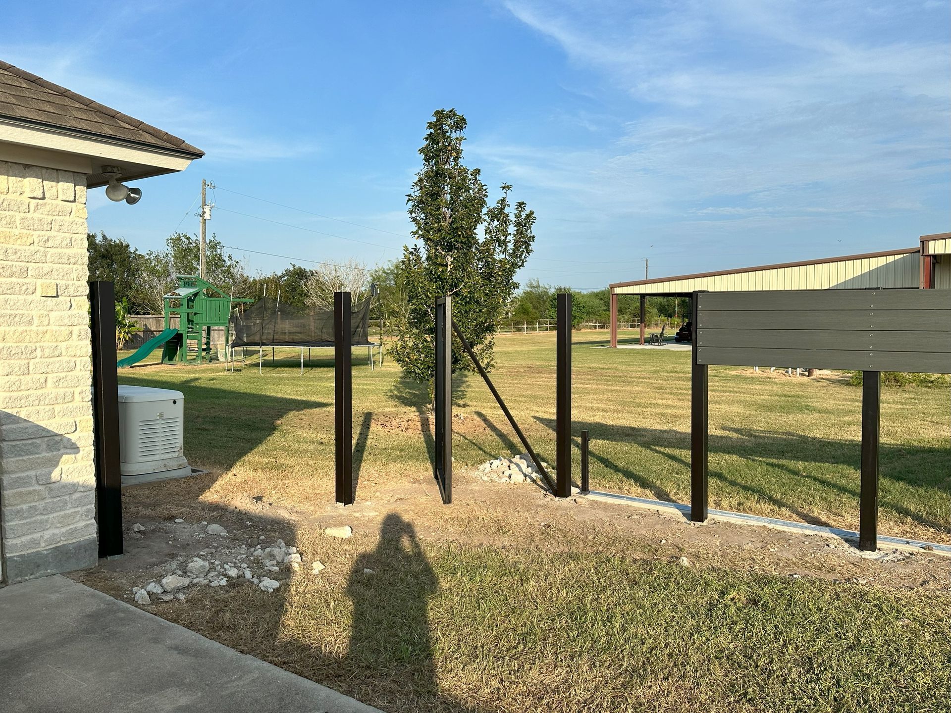 A fence is being built in the backyard of a house.