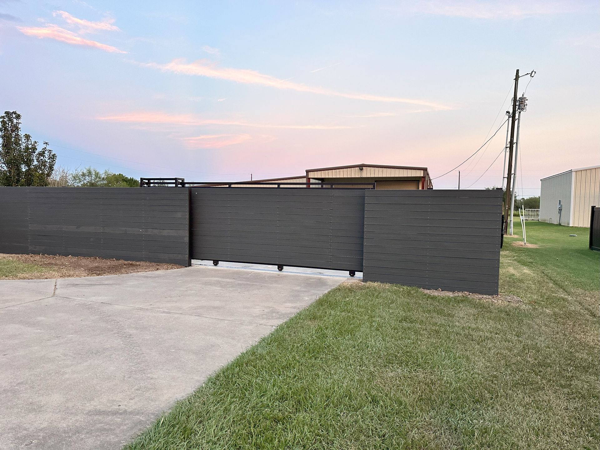 A black fence is sitting in the middle of a grassy field.