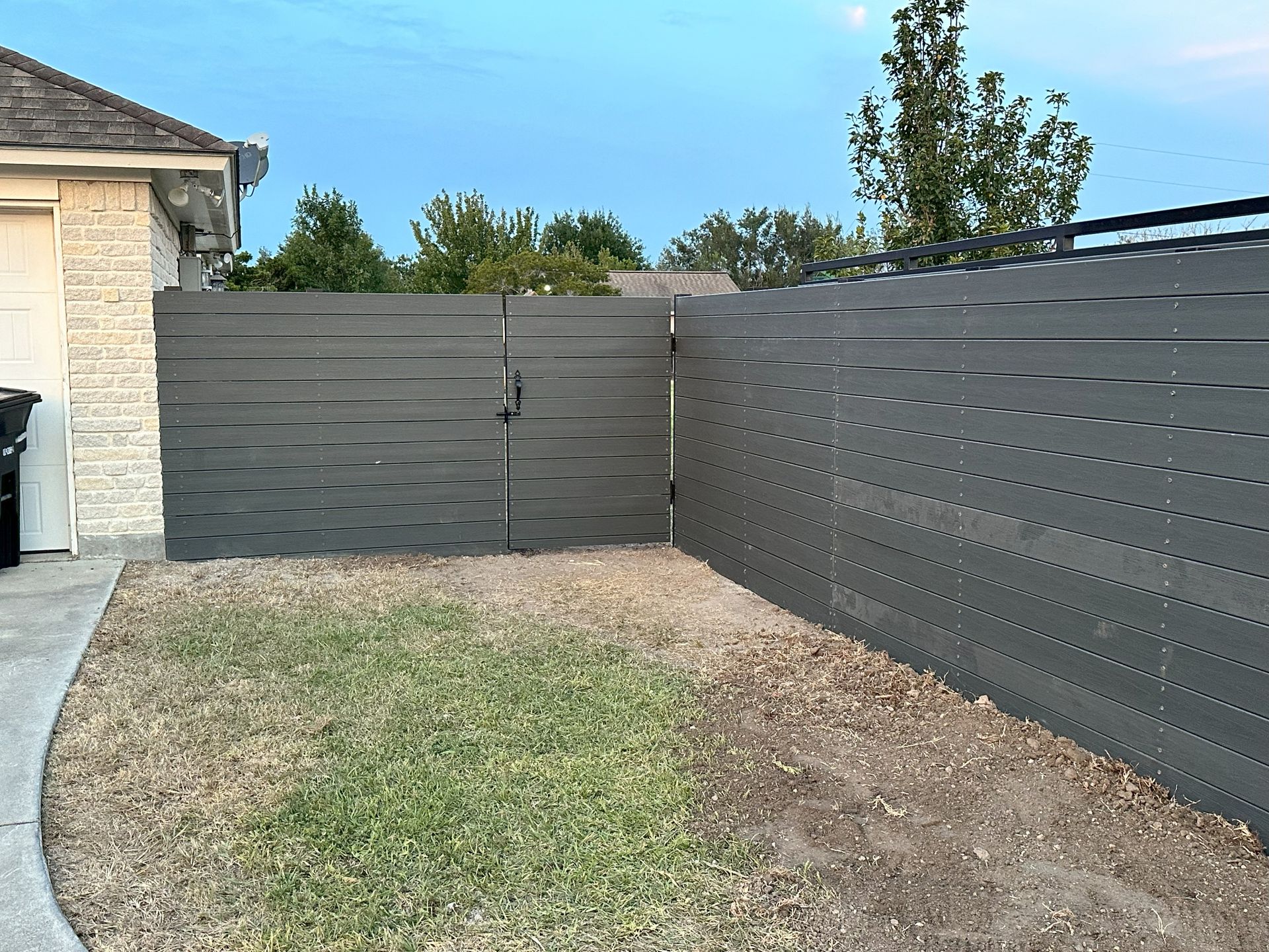There is a fence in the backyard of a house.