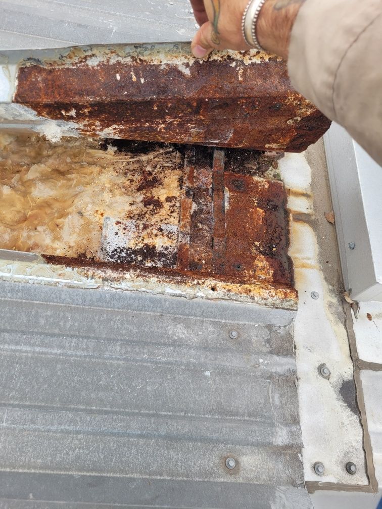 A person is working on a piece of rusty metal