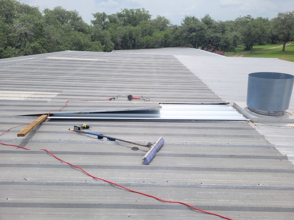 A metal roof is being repaired with tools on it