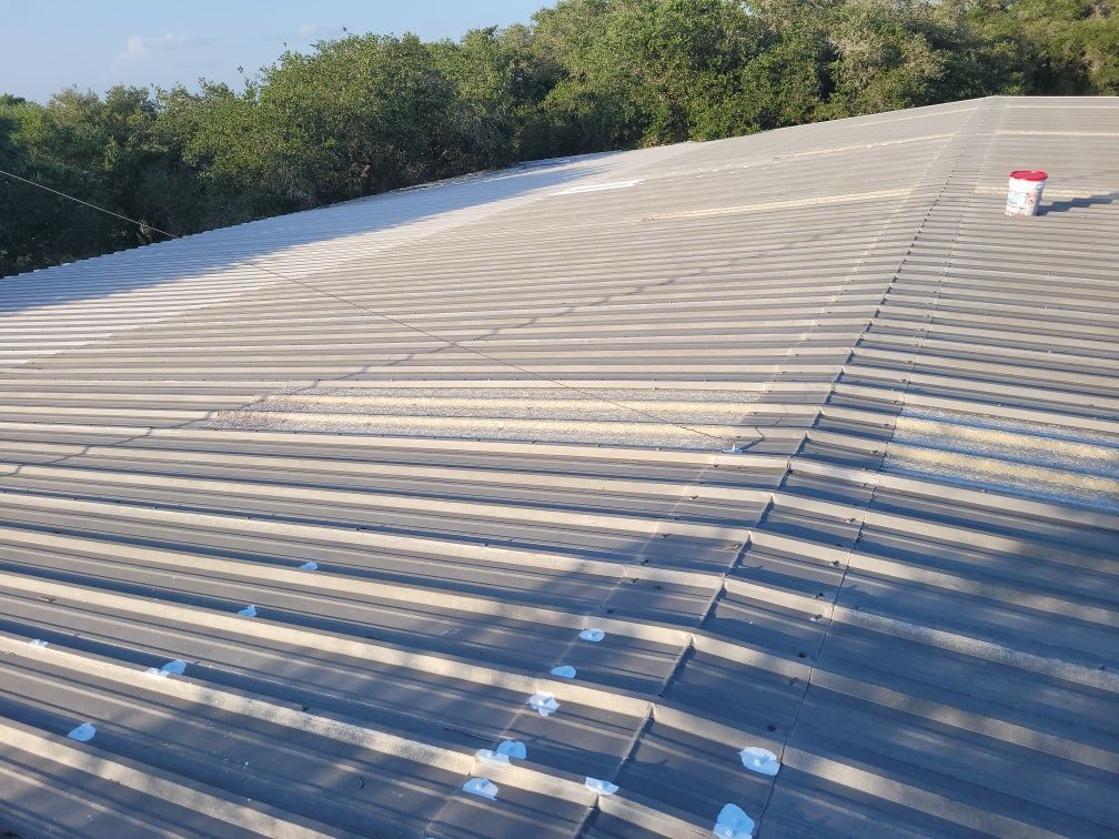 A roof with a bucket on top of it and trees in the background.