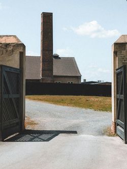 An open gate with a brick chimney in the background