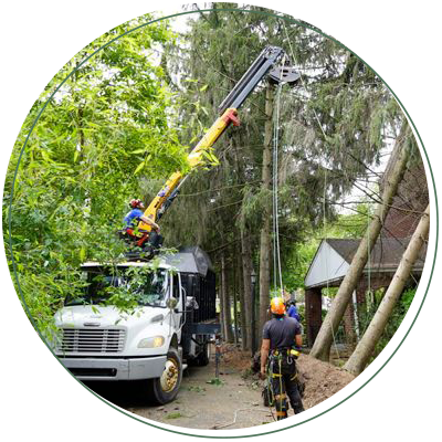 A man is standing next to a truck with a crane attached to it.