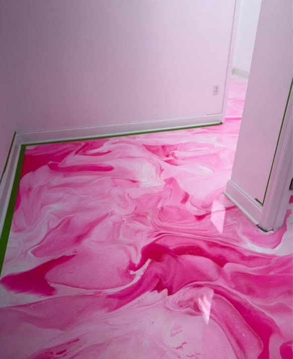 Pink and white swirled epoxy floor in a pink-walled room, near a doorway with white trim.