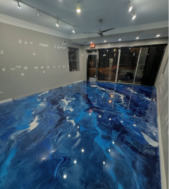 Room with glossy blue and white epoxy floor, neutral walls, and a glass storefront.