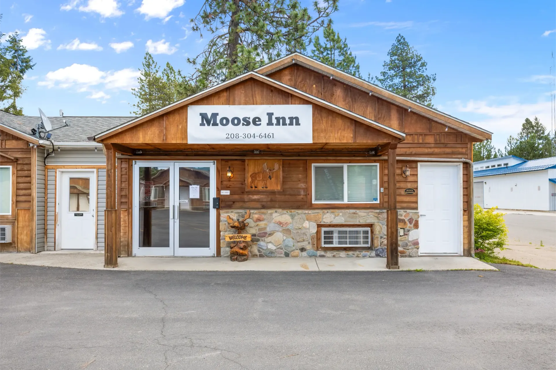 A large wooden building with a sign that says moose inn on it.