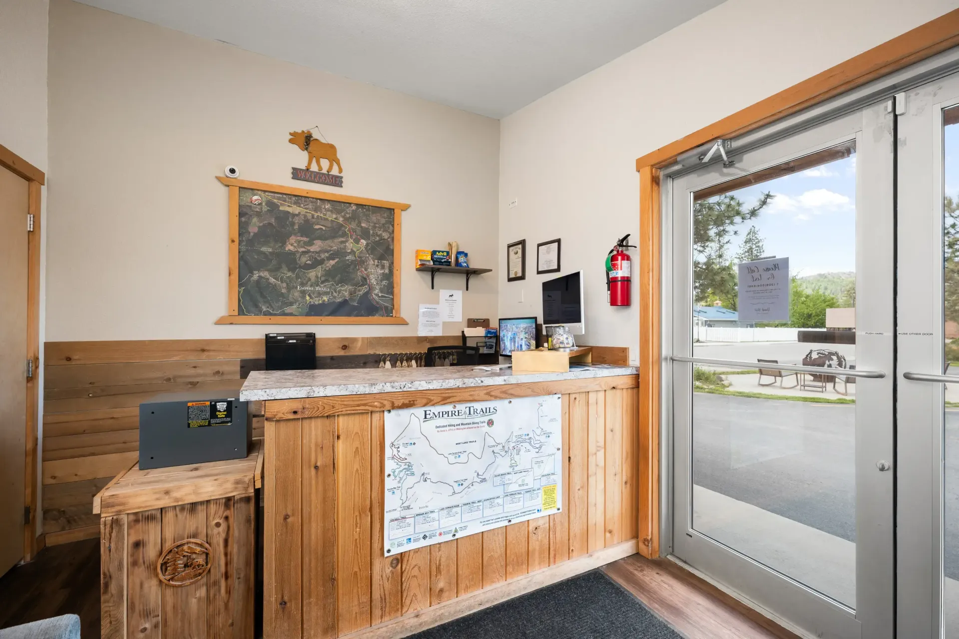 A reception area with a wooden counter and a glass door.