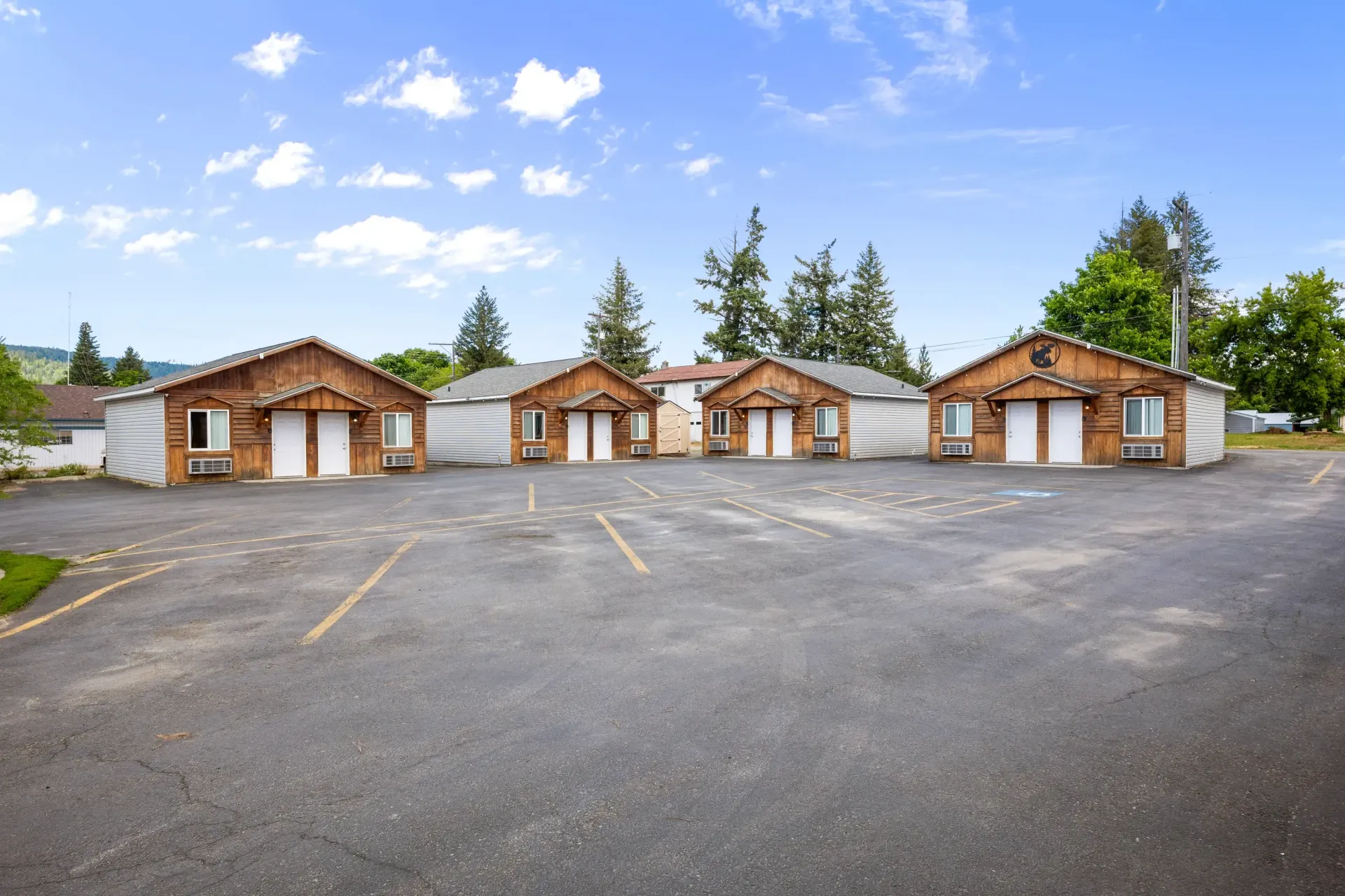 A row of motels are lined up in a parking lot.
