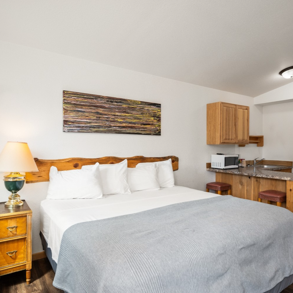 A hotel room with a large bed and a lamp