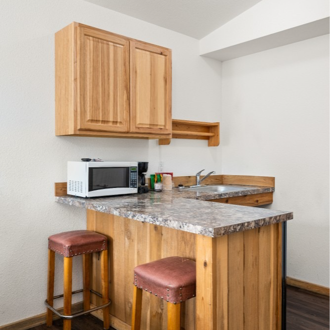 A kitchen with wooden cabinets and marble counter tops