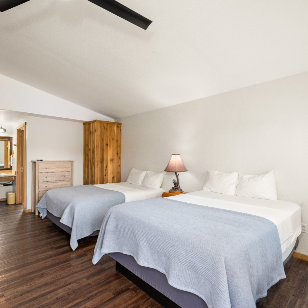 A hotel room with two beds and a ceiling fan