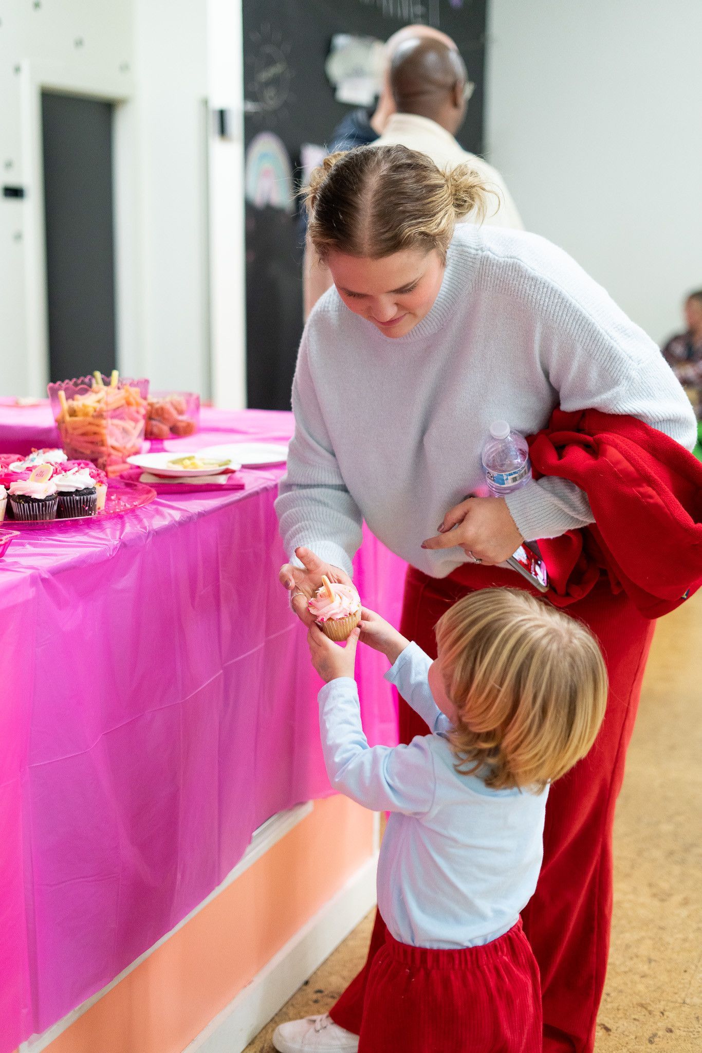 A woman and a child are standing next to each other at a table.