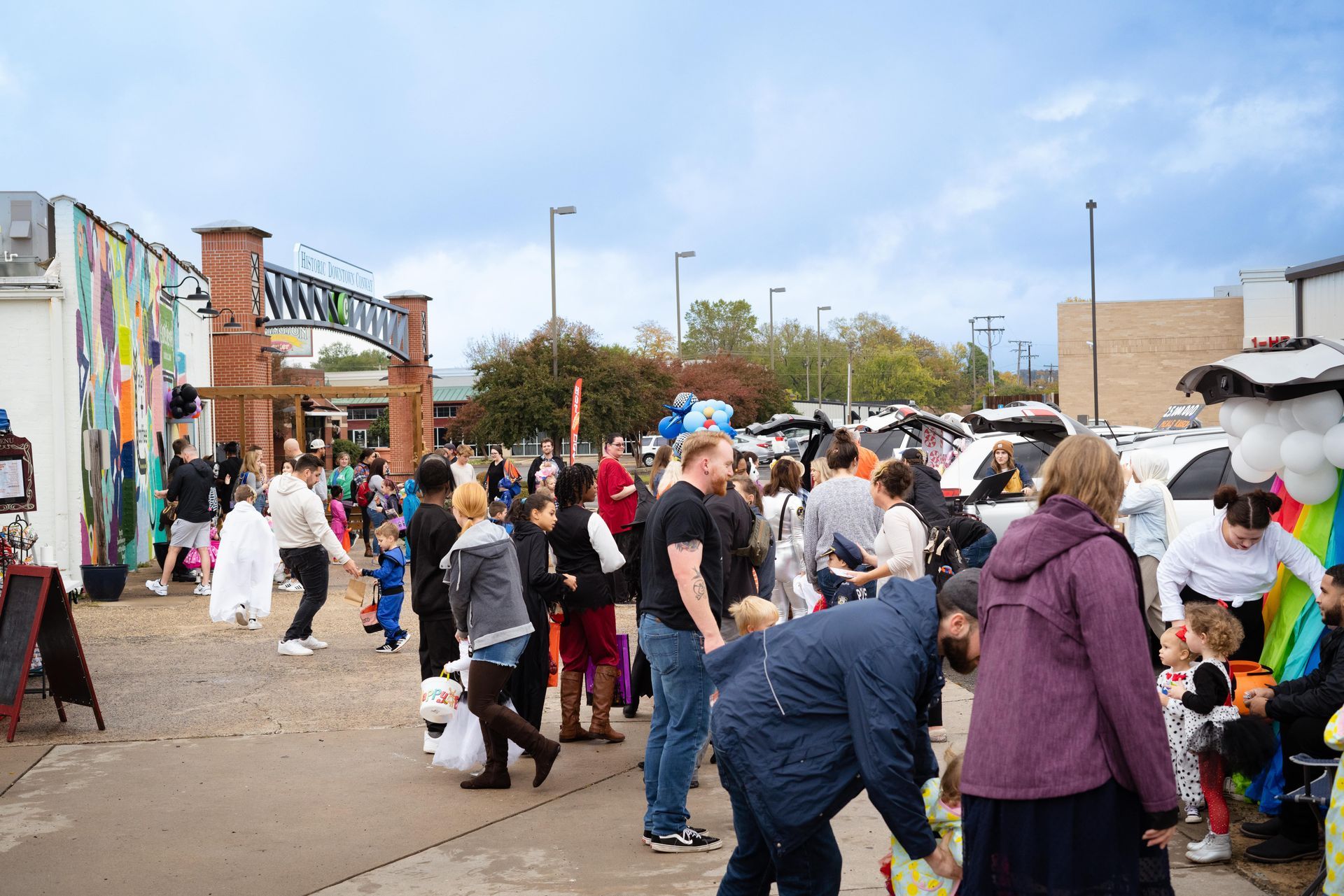 A large group of people are standing in a parking lot.