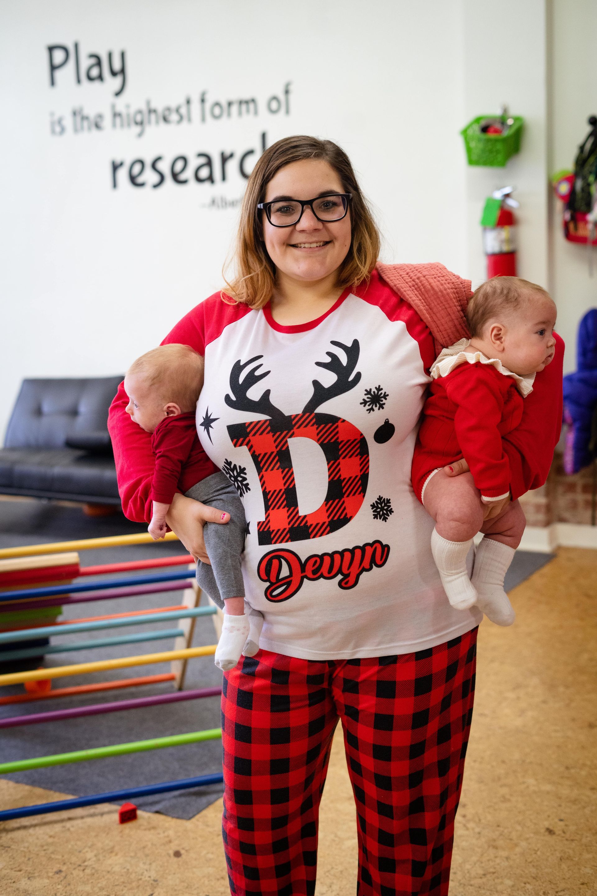 A woman is holding two babies in her arms.
