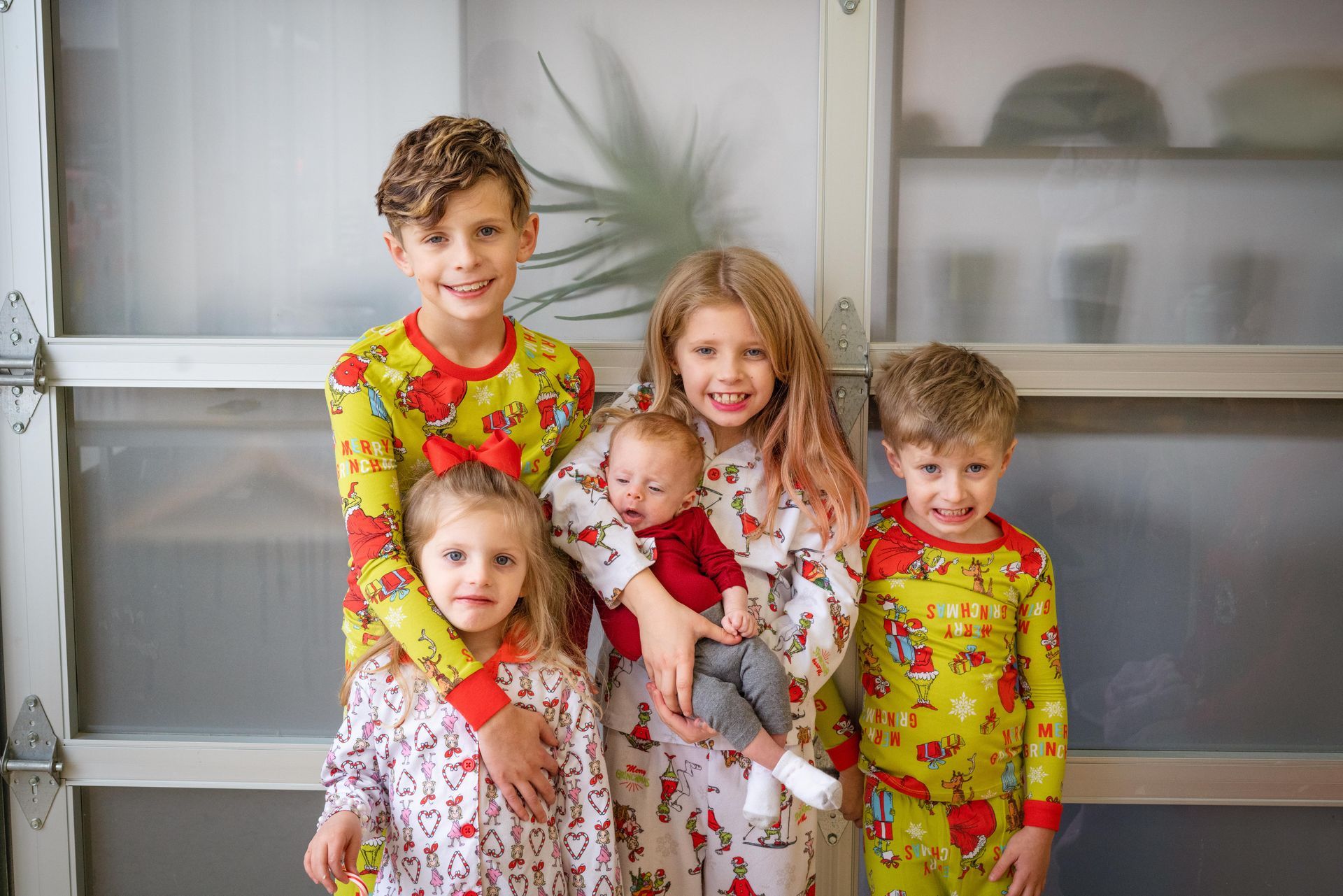 A group of children are posing for a picture in front of a garage door.
