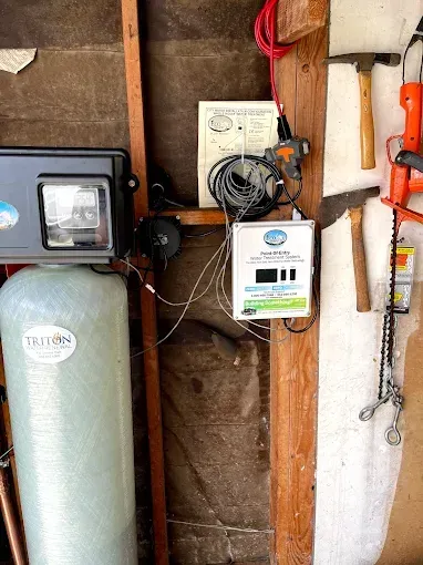 Utility meters and wiring mounted on a wall in a basement or utility room.