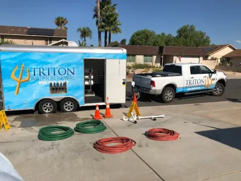 Triton utility trailer and truck with hoses and cones set up on a residential street