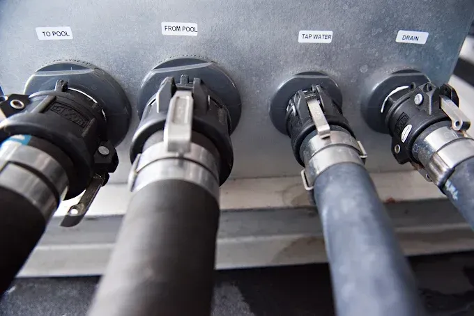 Close-up of four thick black cables plugged into labeled ports on a gray panel.
