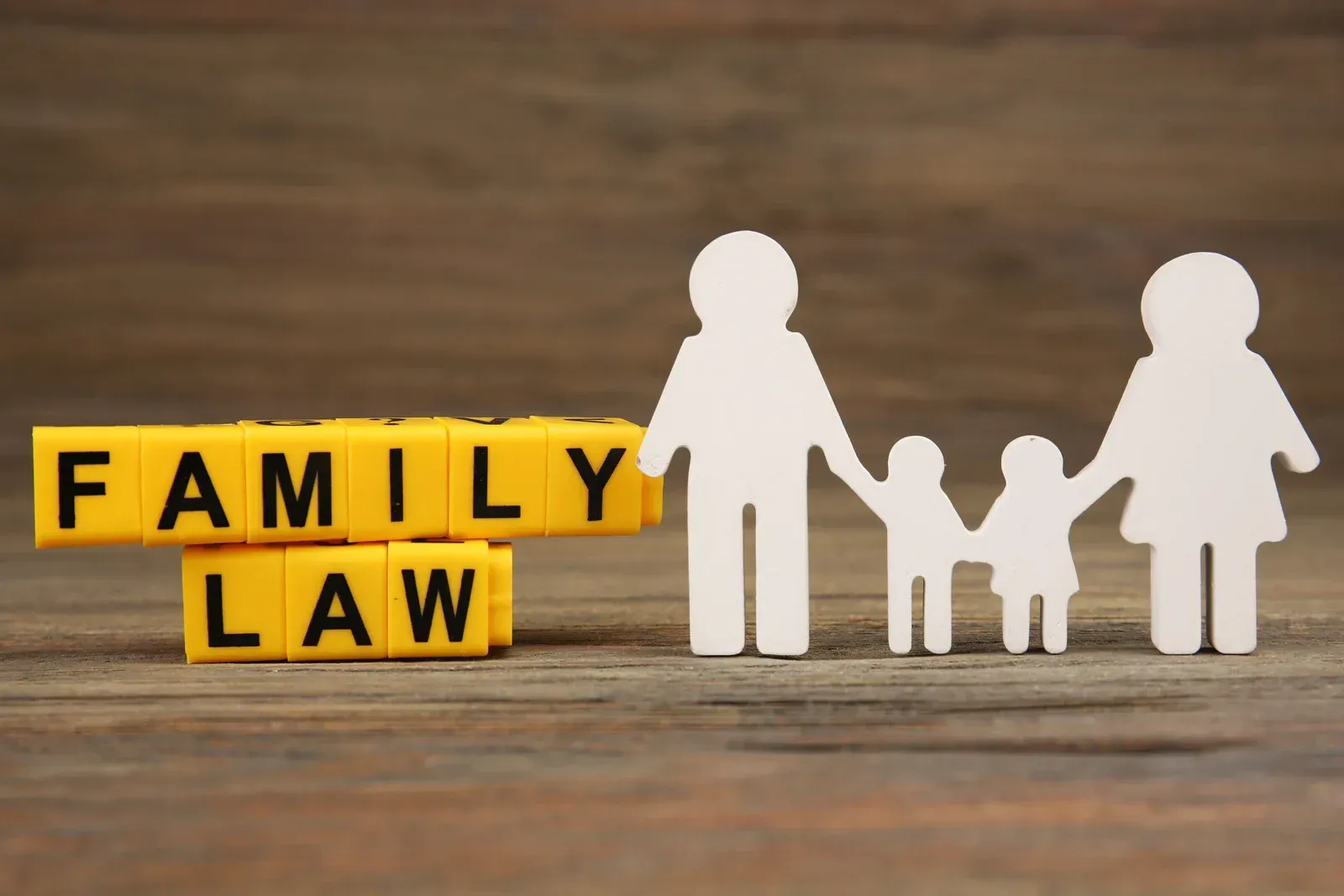 Family law concept: Wooden figures of family with the text "FAMILY LAW" on yellow blocks.