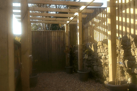 Timber beamed awning over a garden path