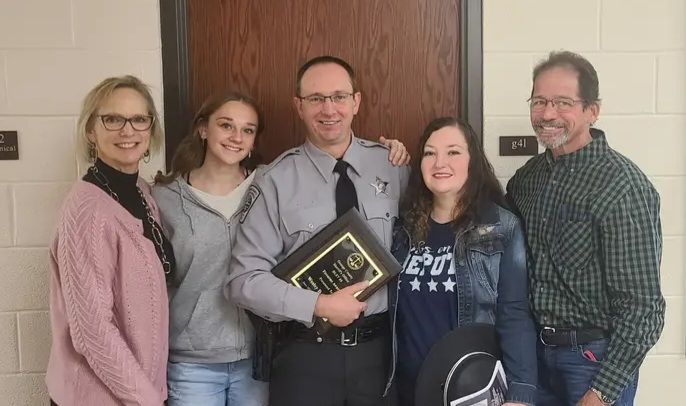 A group of people standing next to each other in front of a door.