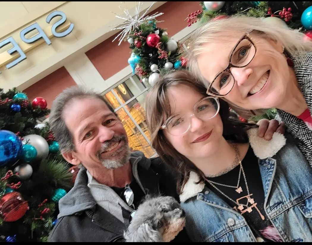 A family posing for a picture in front of a christmas tree.