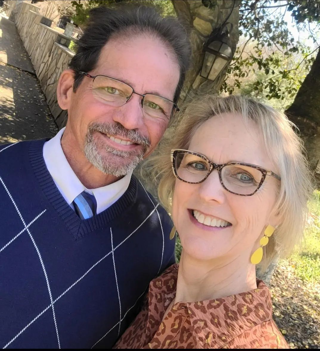 A man and a woman wearing glasses are posing for a picture.