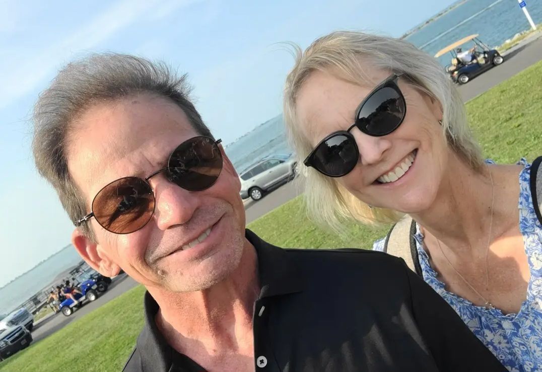 A man and a woman are posing for a picture outside.