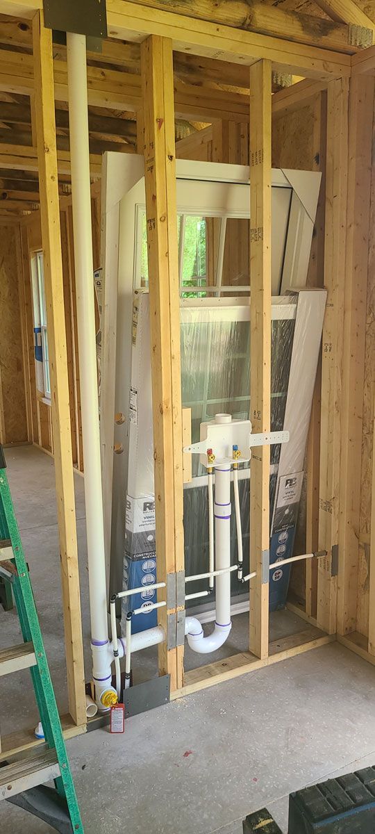 A bathroom under construction in a house with a ladder.