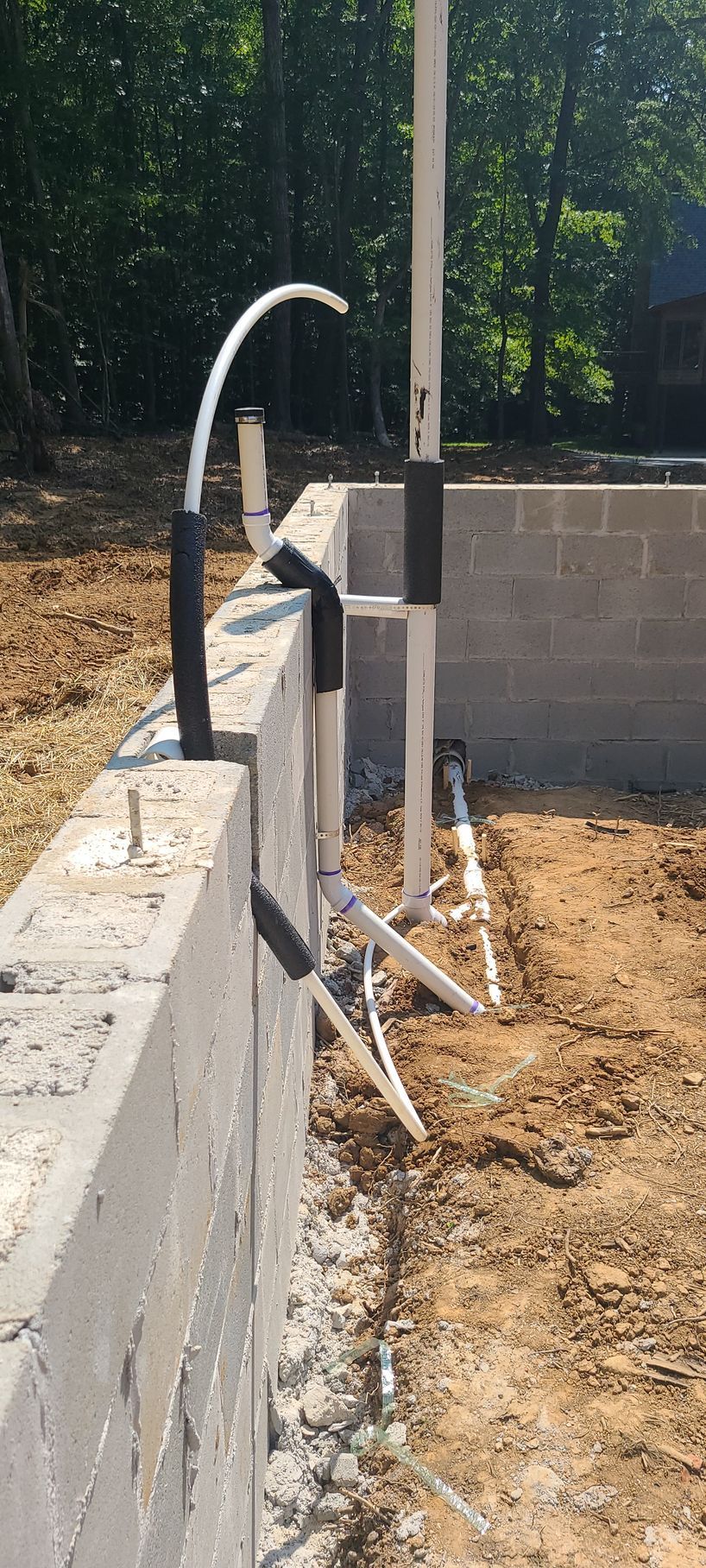 A concrete wall is being built in a dirt field.