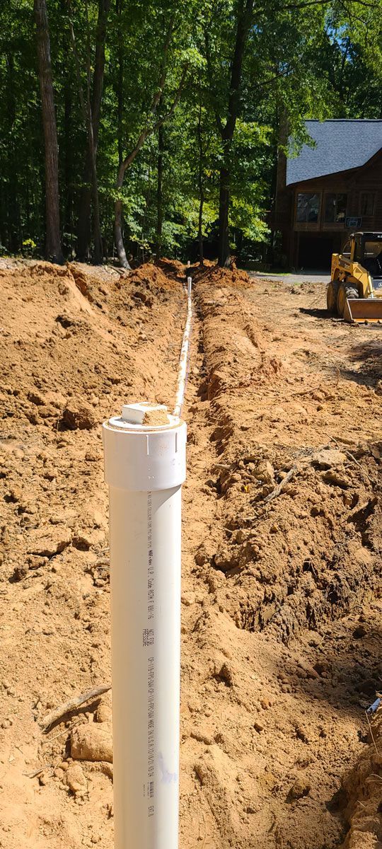 A white pipe is sitting in the middle of a dirt field.