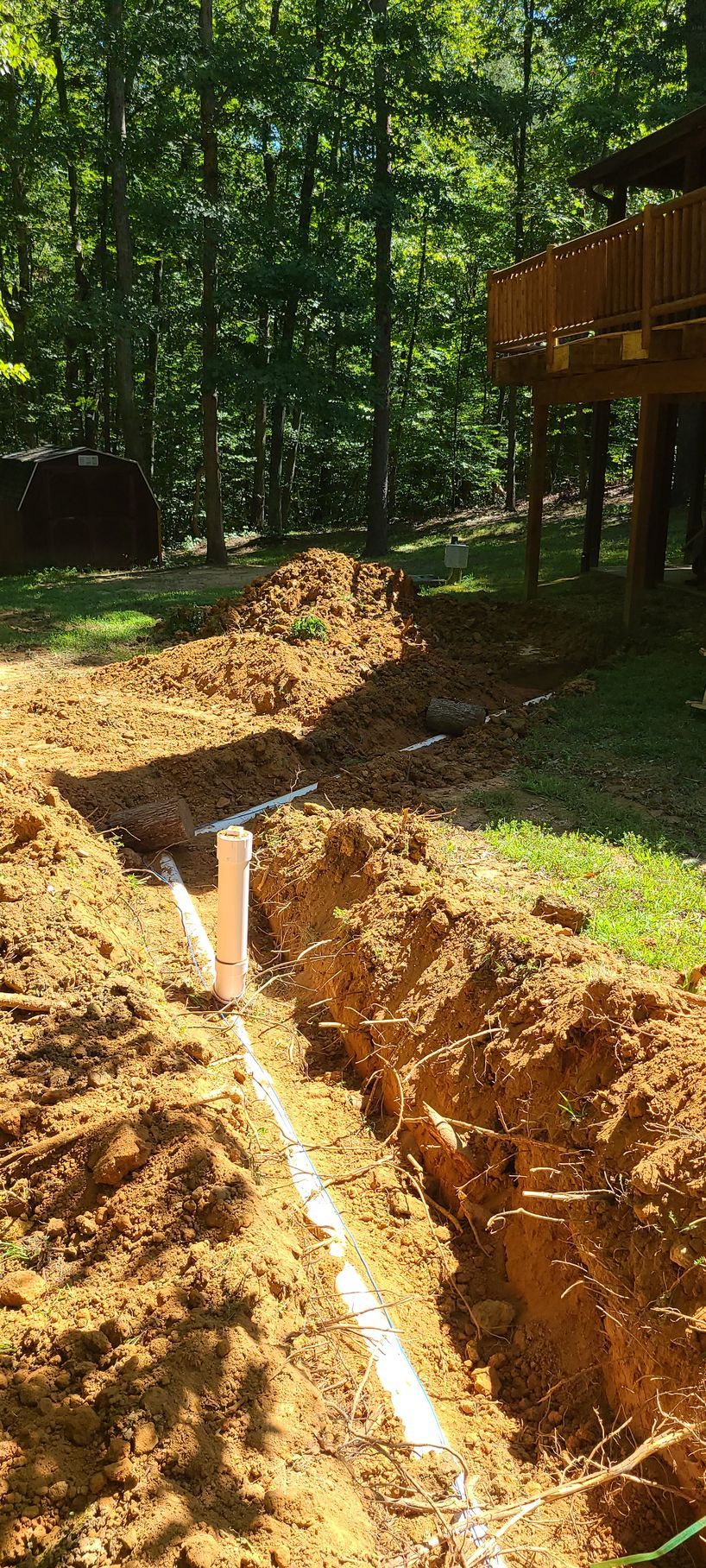 A drainage system is being installed in a backyard.