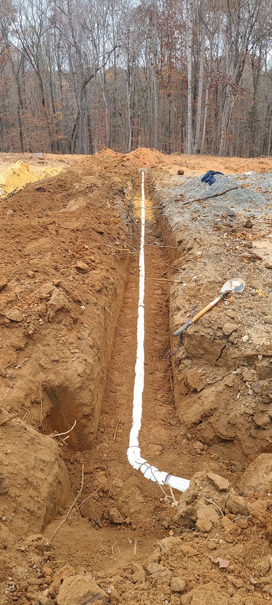 A pipe is being installed in a hole in the ground.