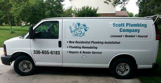 A white van from scott plumbing company is parked in a driveway.