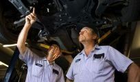 Motor mechanics chatting under a car in Kalgoorlie