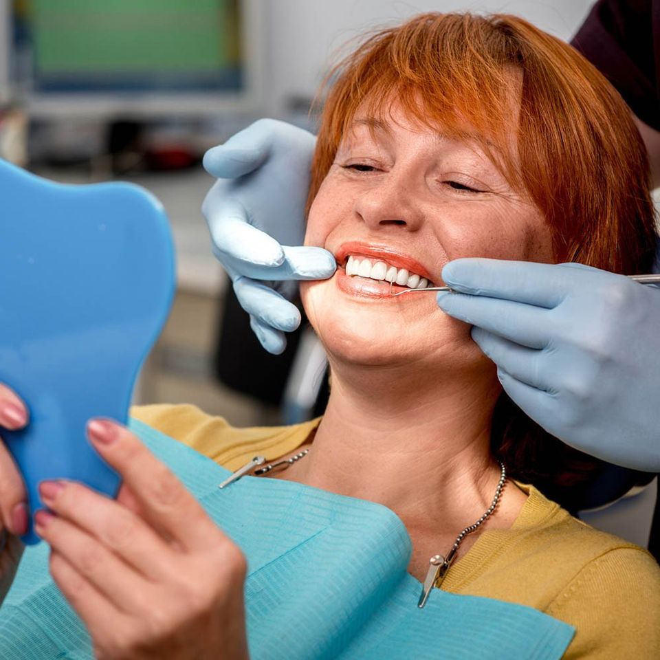 Woman Looking at Her Teeth Through the Mirror — Hickory, NC — McDonald Family Dentistry