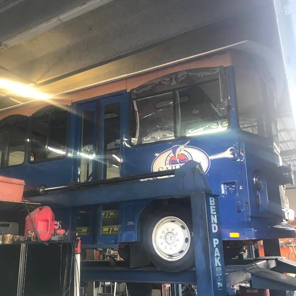 A blue truck is on a lift that says bend pak on it