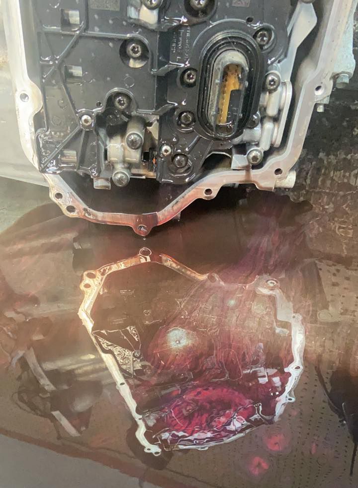 A close up of a car engine with water coming out of it.