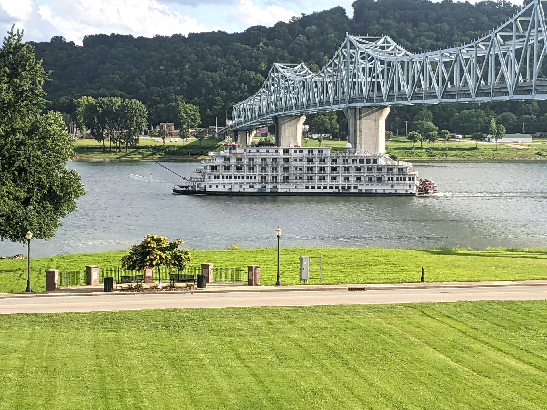 A cruise ship is going under a bridge over a river