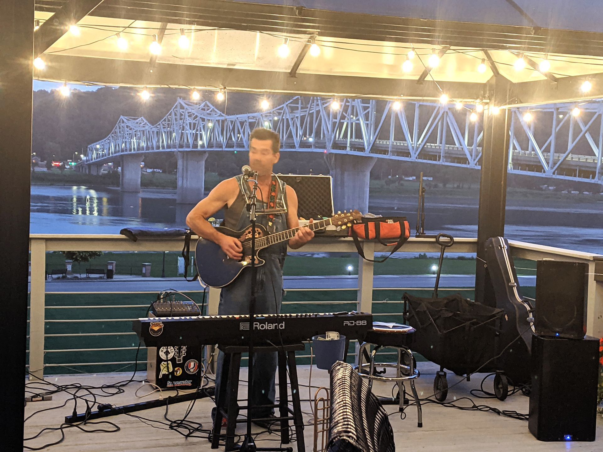 A man is playing a guitar and singing into a microphone on a stage.