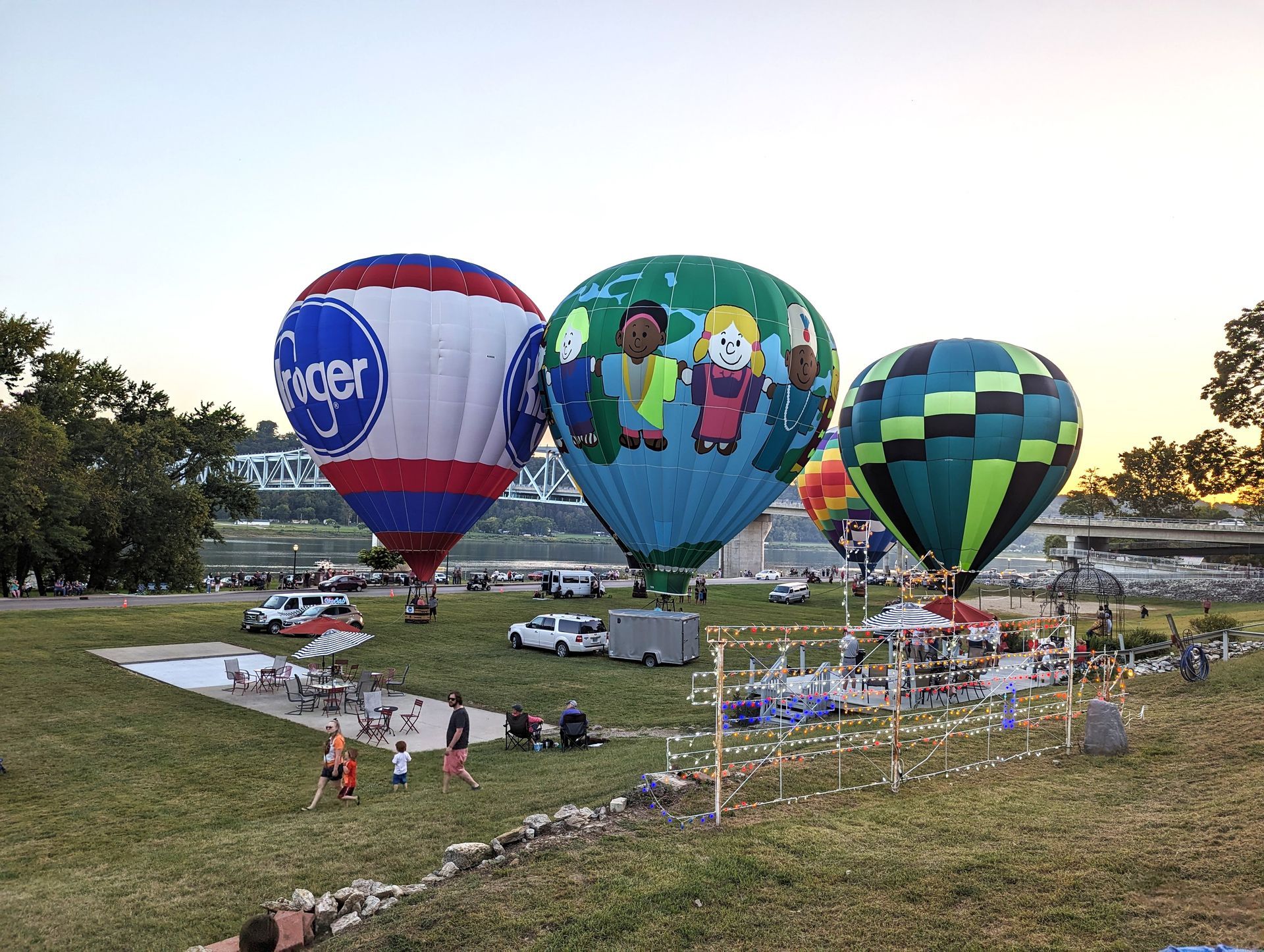 A group of hot air balloons are sitting on top of a grassy field.