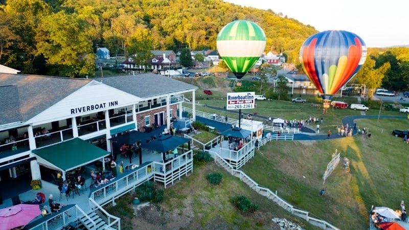 A group of hot air balloons are flying over a building.