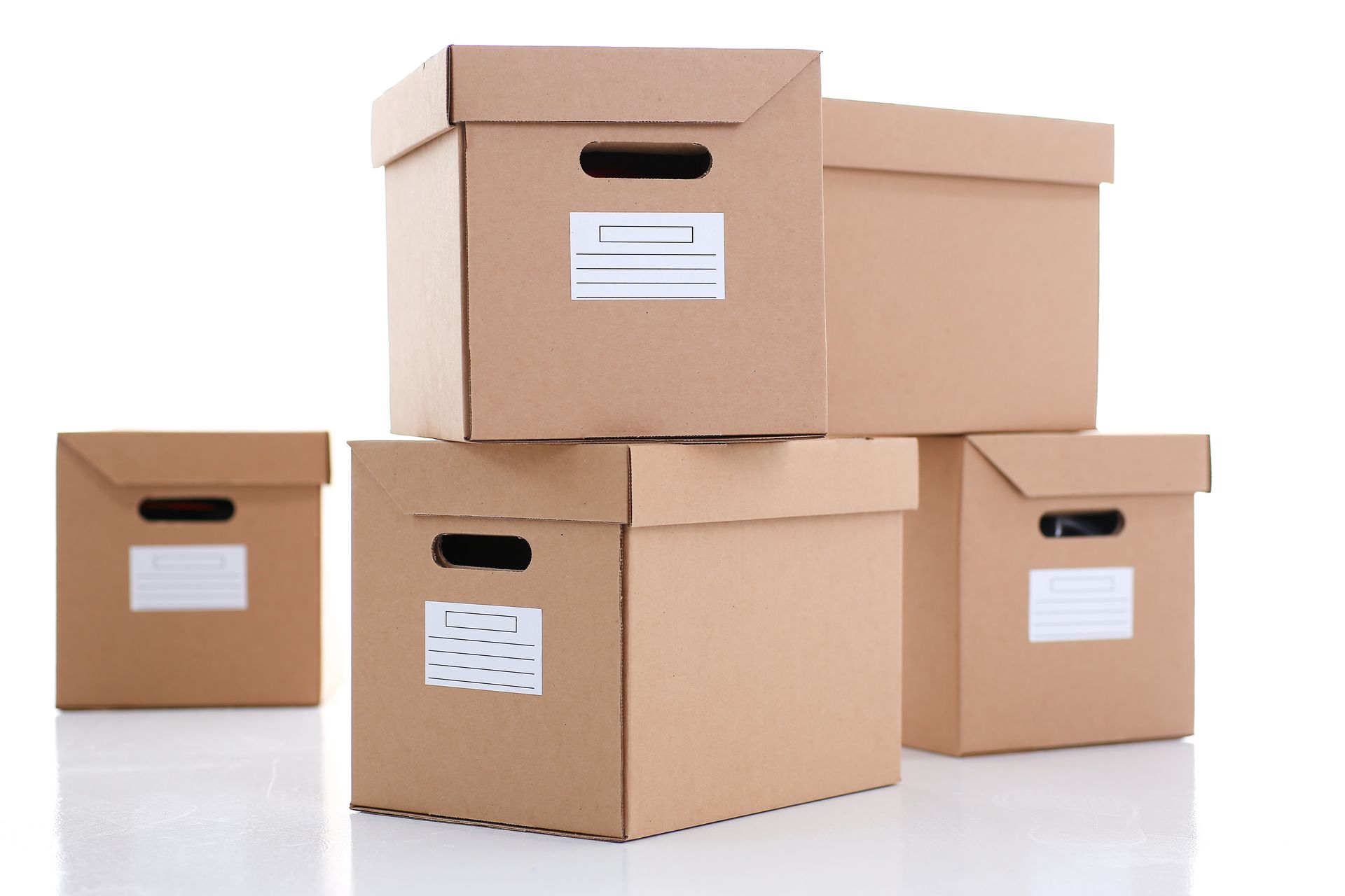 bandejas de almacenamiento Cinco cajas de cartón apiladas con etiquetas, sobre una superficie blanca.