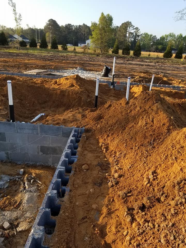 A pile of dirt is sitting next to a brick wall.