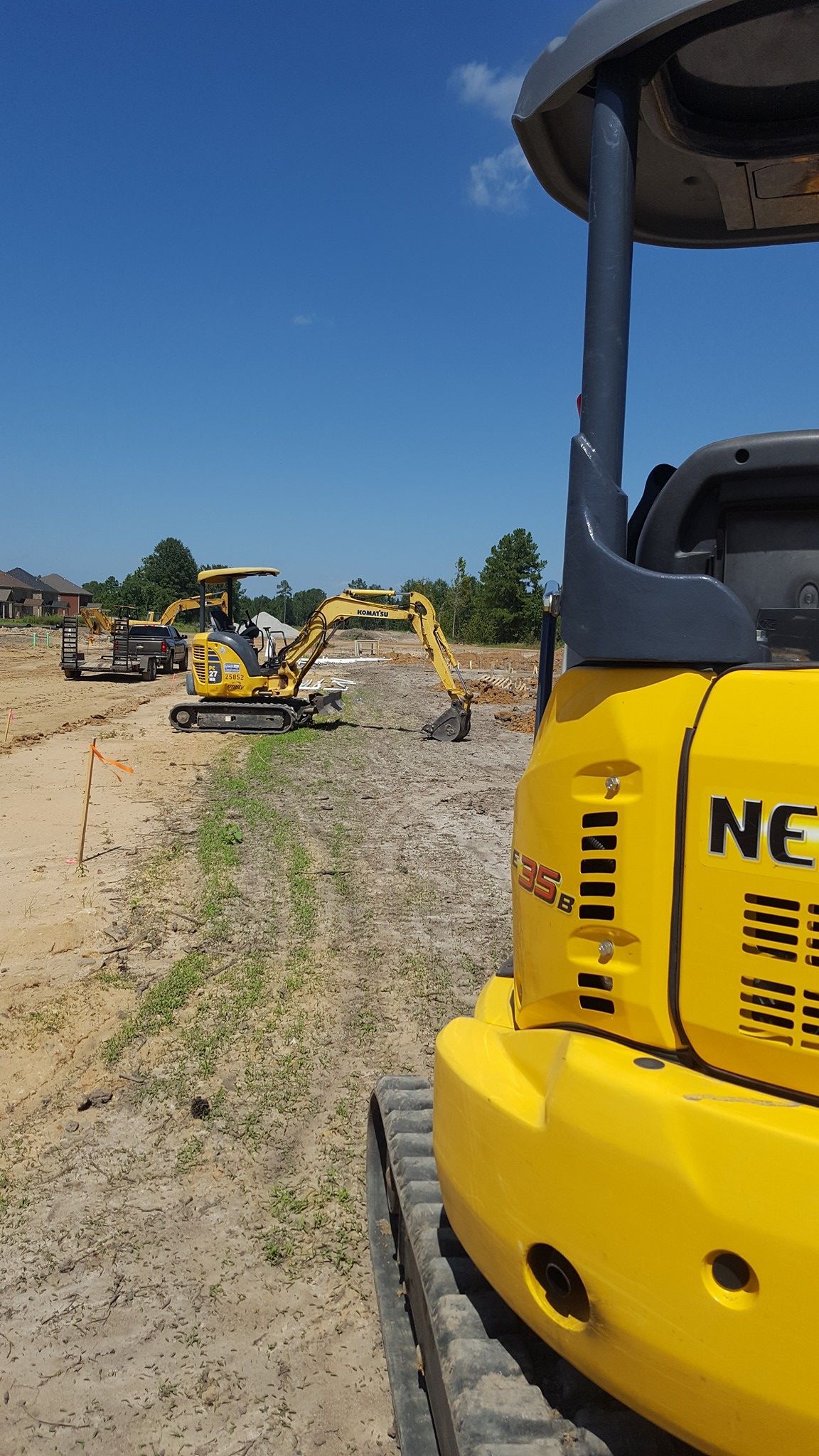 A yellow excavator is parked in a dirt field.