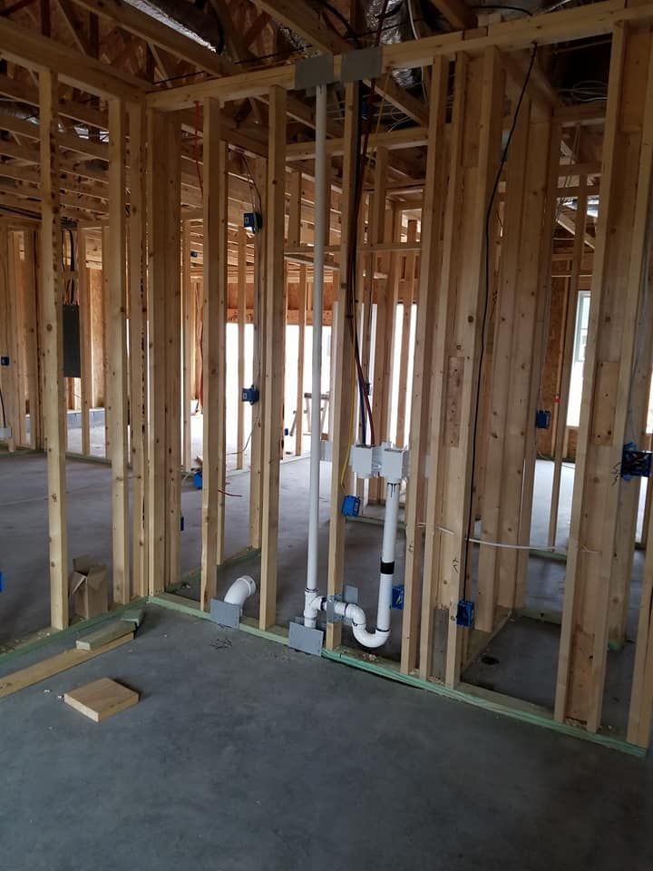 A room in a house under construction with pipes in it