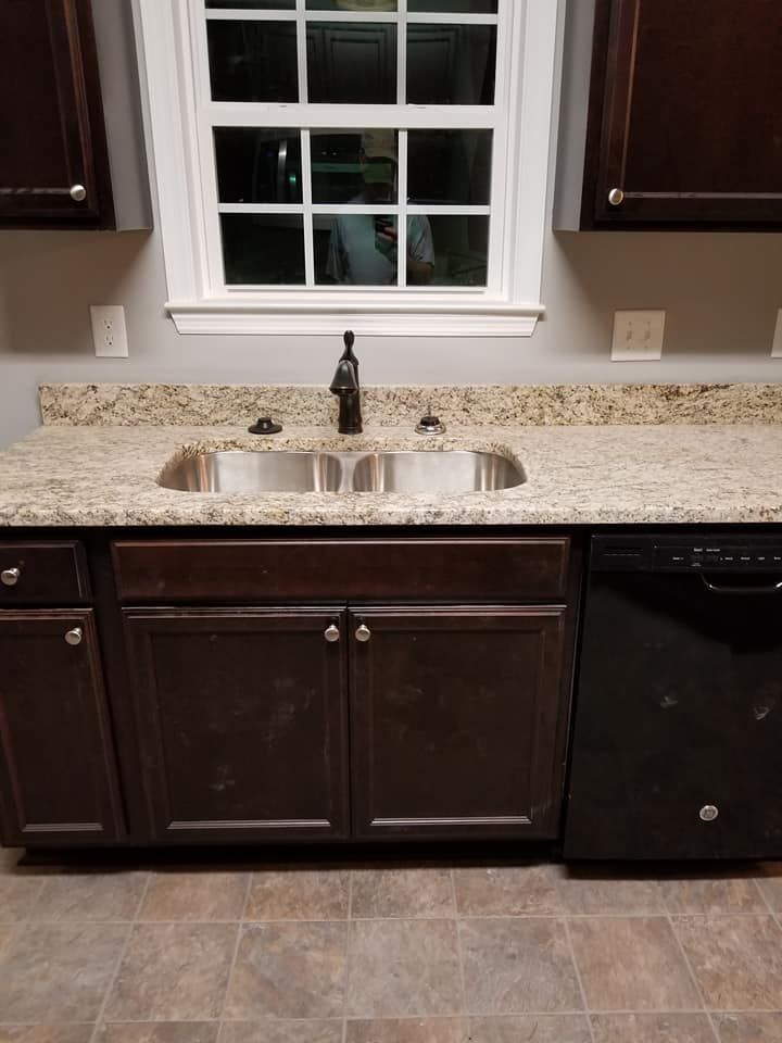 A kitchen with two sinks and a black dishwasher.
