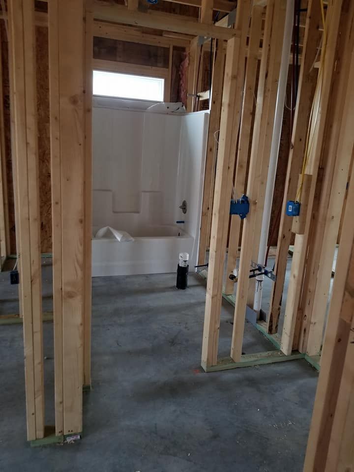 A bathroom in a house under construction with a bathtub.